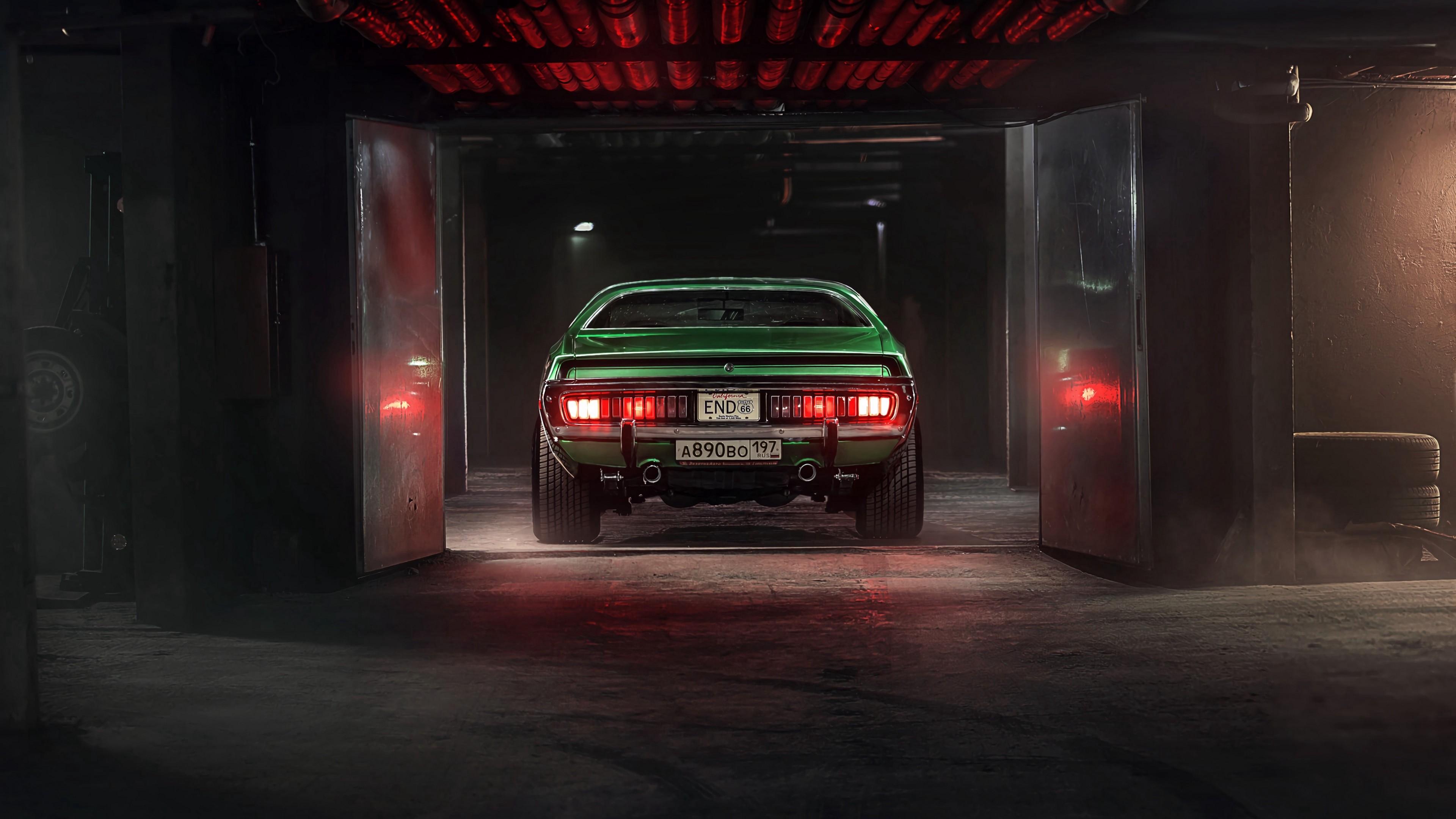 Auto clásico verde con las luces traseras encendidas entrando a un taller
